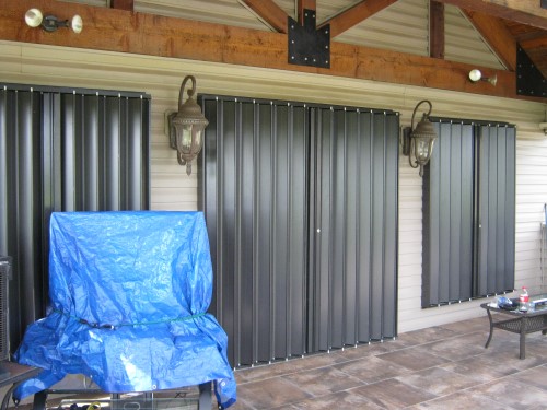 bronze accordion shutters closed in preparation for storm