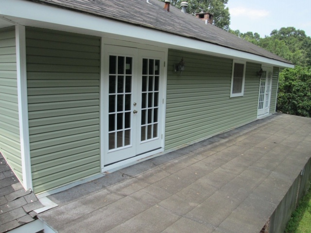 after transformation white fiberglass doors on green siding