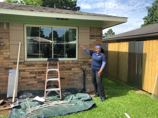 woman standing smiling in front of newly installed picture windows